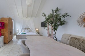 Une chambre à coucher avec un lit, une table de chevet, un miroir, une plante et une armoire en bois.