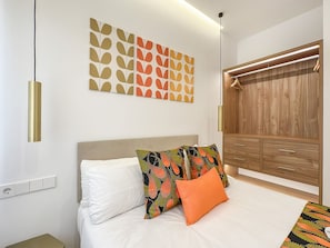 A bedroom with a bed, a wardrobe, and a wall-mounted light fixture. - Spacious 2BR/2BA Close Plaza España Berlany España (Madrid)