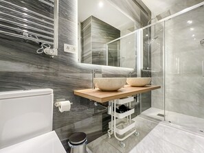A modern bathroom with a large mirror, two vessel sinks, a shower enclosure, and a toilet. - Spacious 2BR/2BA Close Plaza España Berlany España (Madrid)