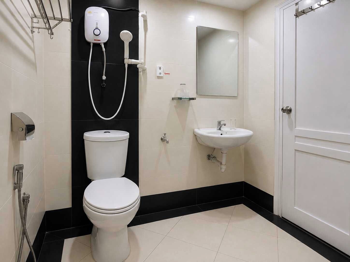 A bathroom with a toilet, a sink, and a shower unit.