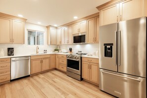 A modern kitchen with wooden cabinets, stainless steel appliances, and a built-in oven. - Ski-in/ski-out 3BR condo with resort amenities and slope views. (Park City)