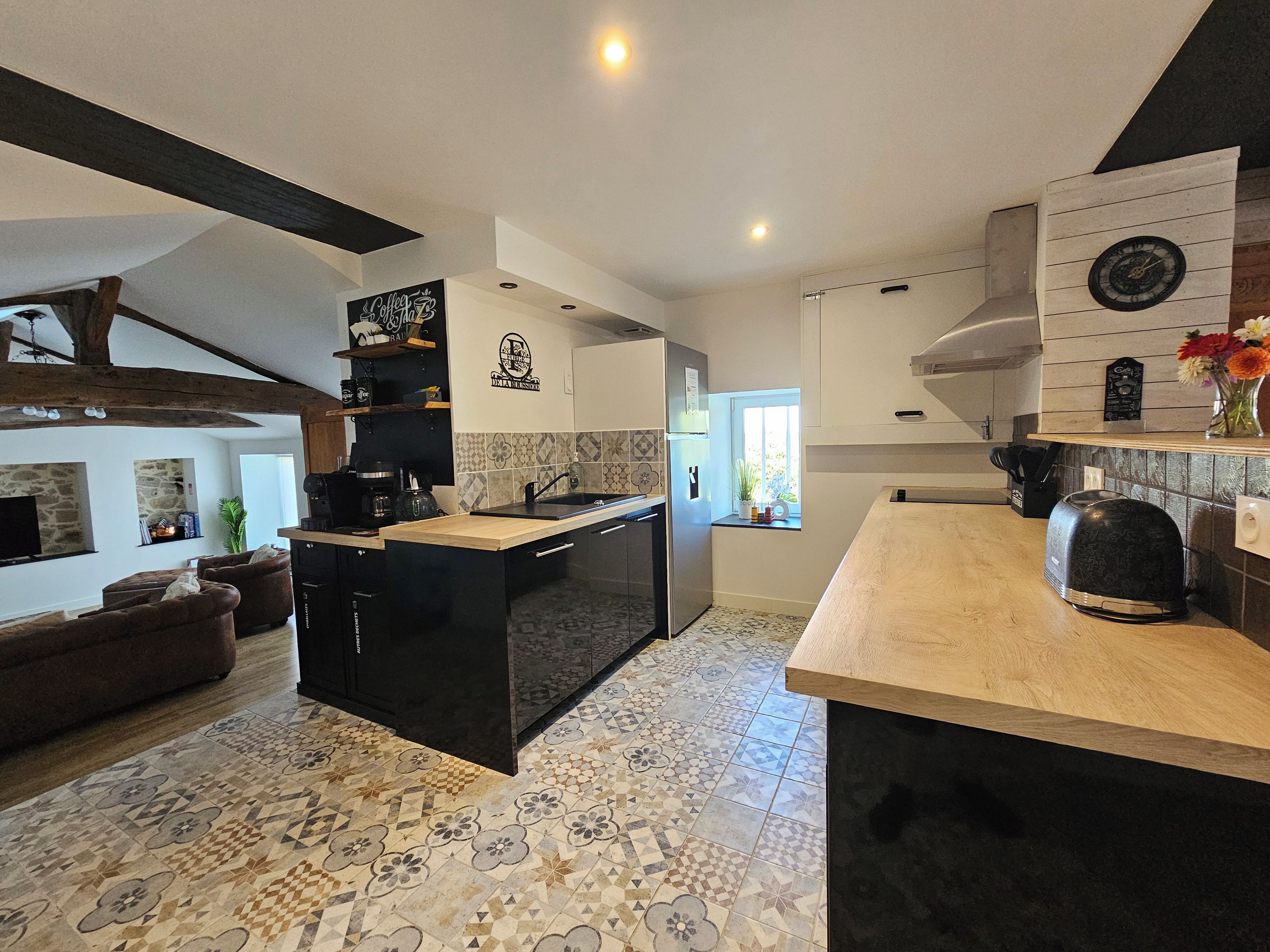 A modern kitchen with a central island, a built-in oven, and a window providing natural light.