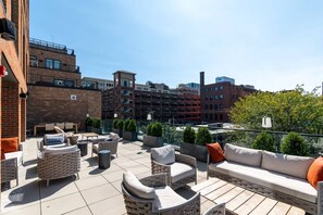 An outdoor patio with seating arrangements and a view of surrounding buildings. - Downtown Cincinnati | Free Parking, Pool & Gym (Cincinnati)