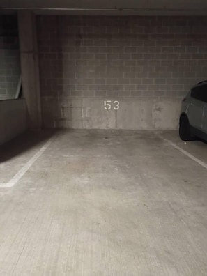 An empty parking garage with concrete walls and a numbered parking space. - Downtown Cincinnati | Free Parking, Pool & Gym (Cincinnati)