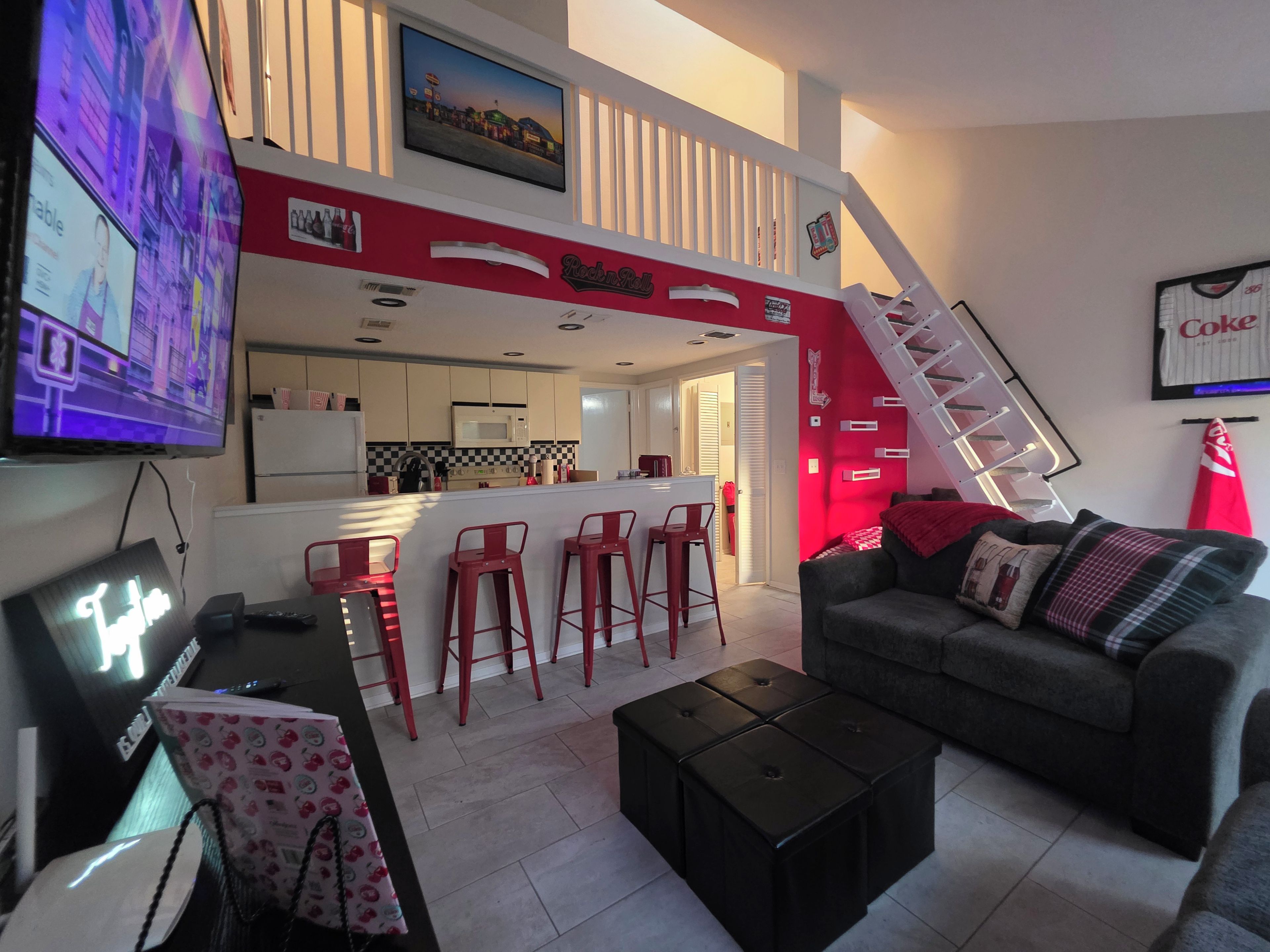 A modern living room with a sofa, a coffee table, and a TV mounted on the wall.