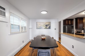 A modern kitchen with dark wood cabinets, a stainless steel refrigerator, and a granite countertop. - Jersey City Heights 3BR condo, sleeps 6, private entrance + driveway parking (Jersey City)