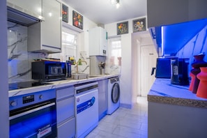 Una cocina moderna con microondas, horno, lavavajillas y lavadora.