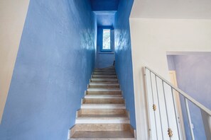 A staircase with blue walls and a white railing leading to a landing. - Villa Tigli: A 5-Minute Walk From the Beach by Top Villas Sardinia (Quartu Sant'Elena)
