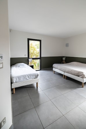 A room with two beds, a window, and a door. - 6-Bedroom Vacation Rental - ALTER ET GO! Vacation Rental Village - Panoramic view (MARQUIXANES)