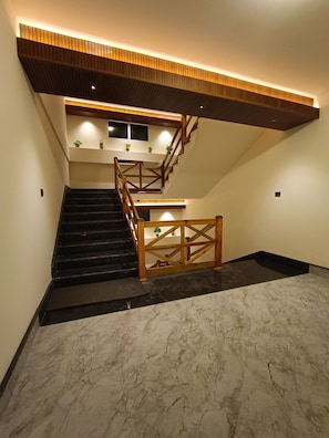 A modern staircase with wooden railings and a marble floor. - Sunhill Ravangla Retreat (Ravangla)