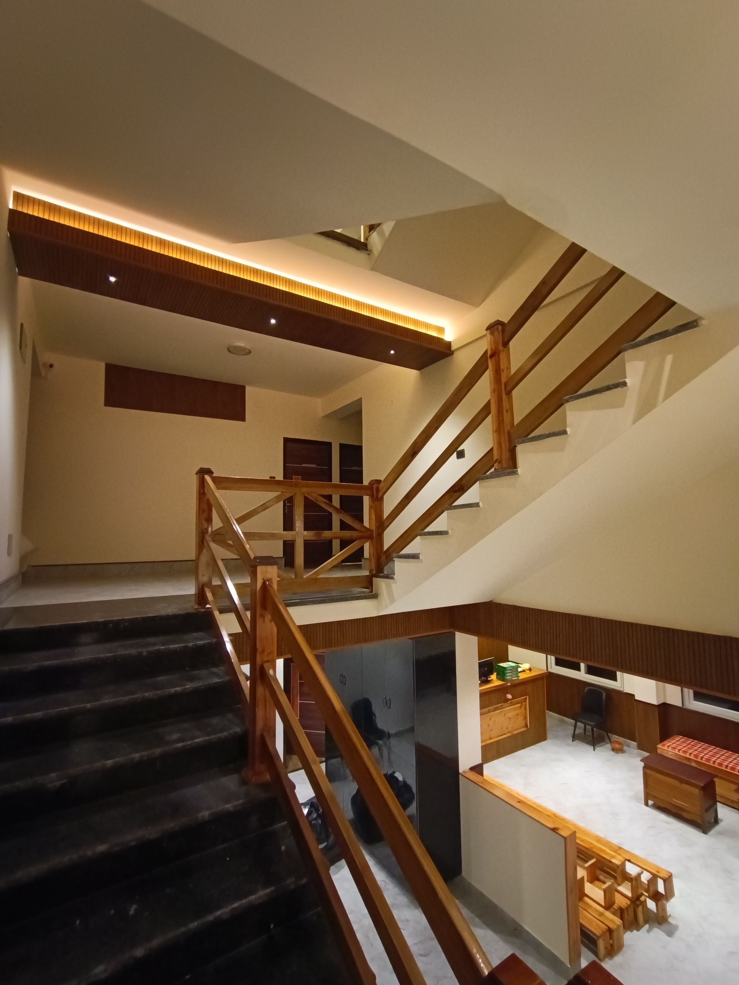 A multi-level interior with a staircase, a kitchen area, and a seating space.
