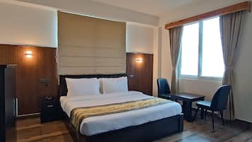 Een moderne hotelkamer met een groot bed, een bureau en een stoel.