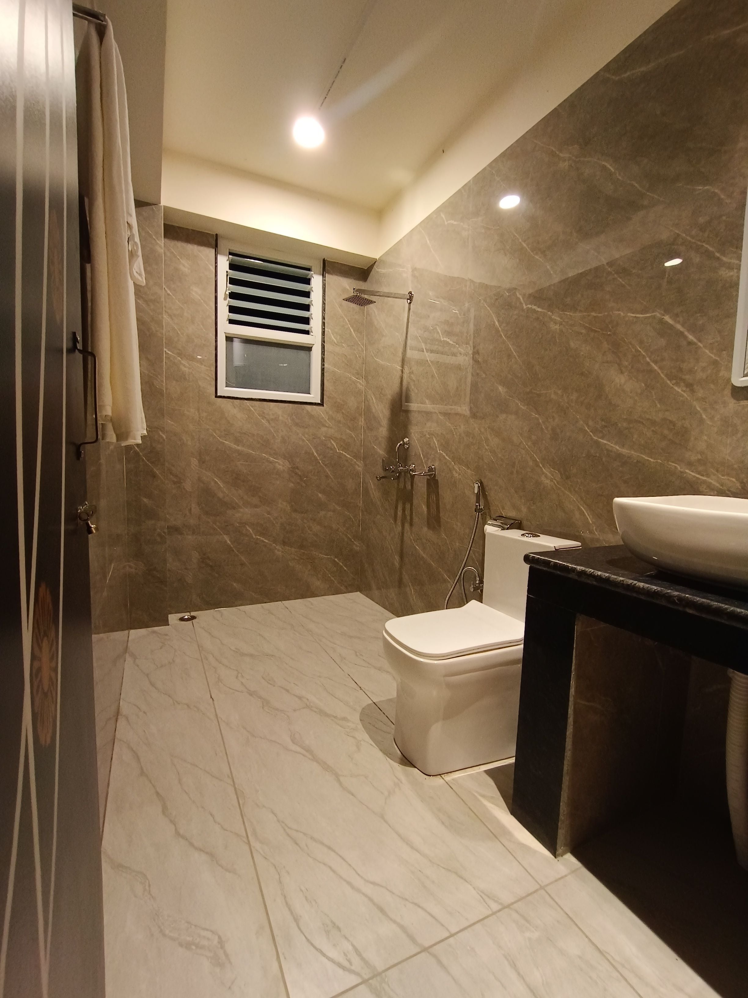 A modern bathroom with a shower, toilet, and sink.