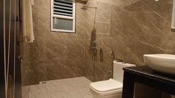 A modern bathroom with a shower, toilet, and sink.