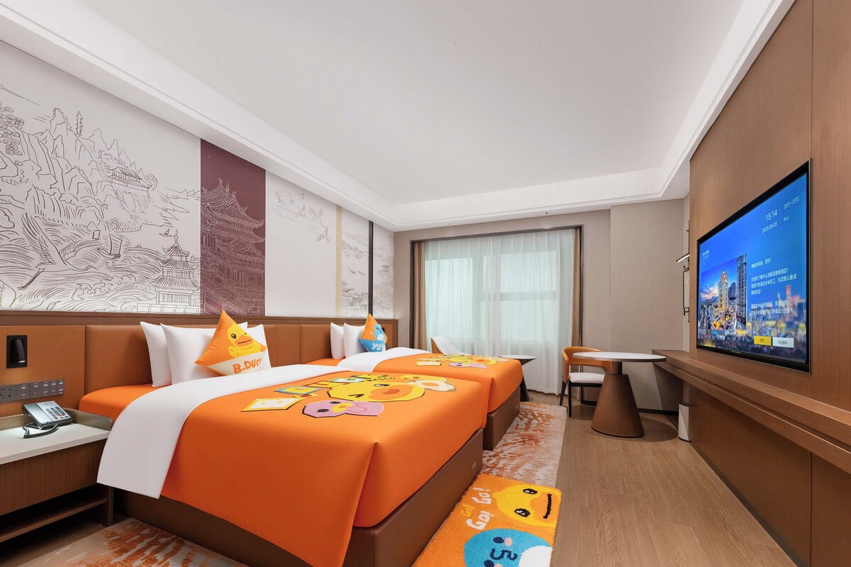 Une chambre d’hôtel avec un lit, un bureau, une chaise, une télévision et une grande fenêtre.