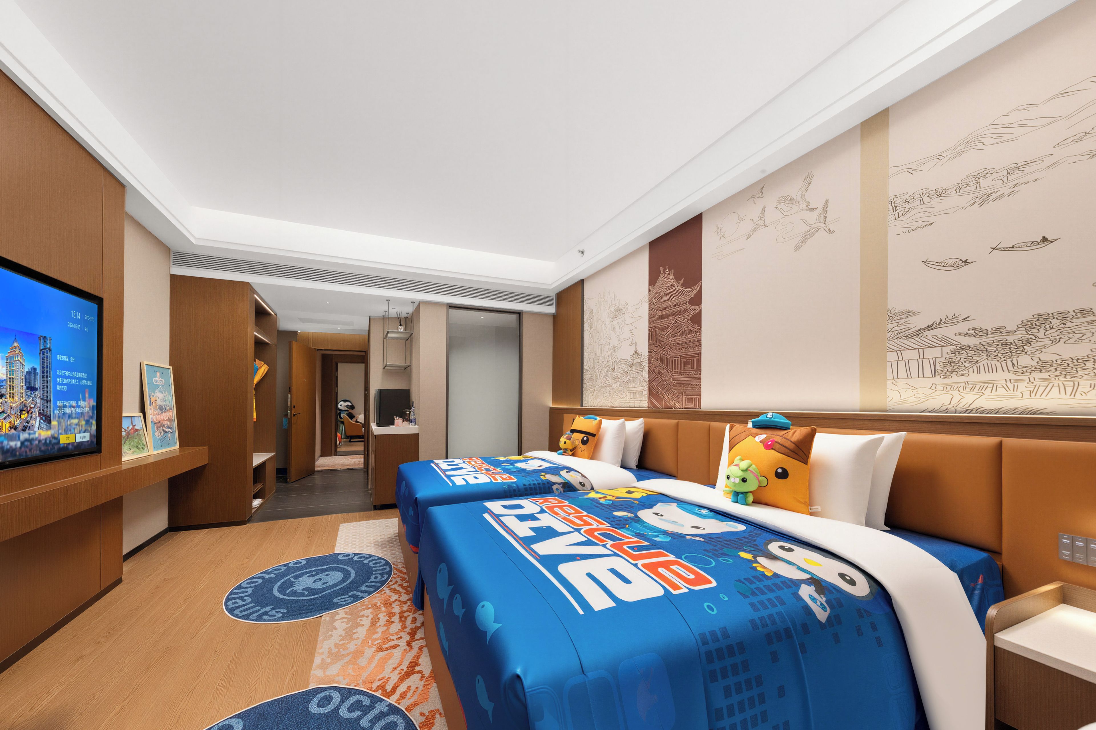 Una habitación de hotel con una cama grande, un televisor en la pared y un mural.
