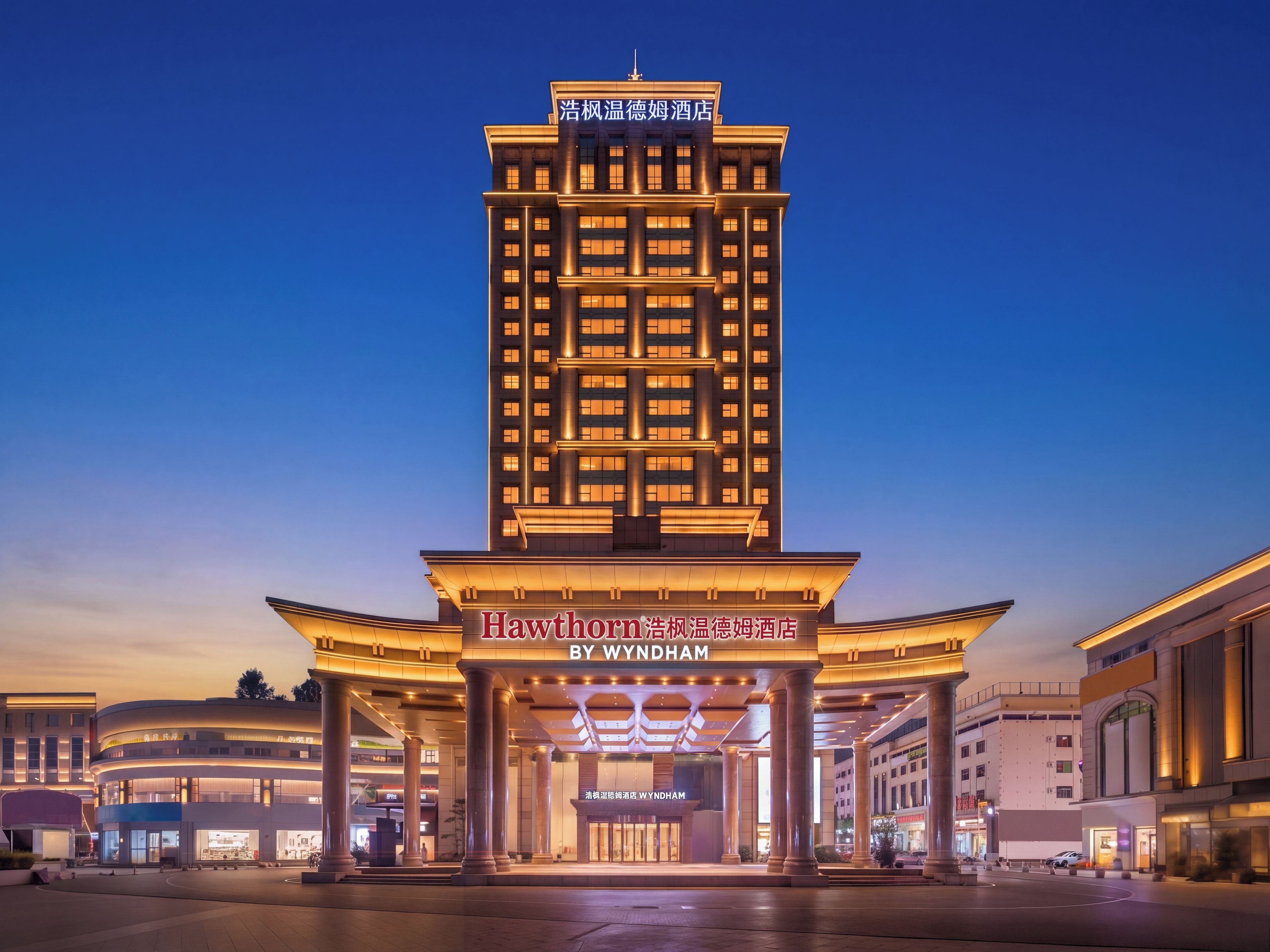 A hotel with a prominent entrance, multiple floors, and illuminated signage.
