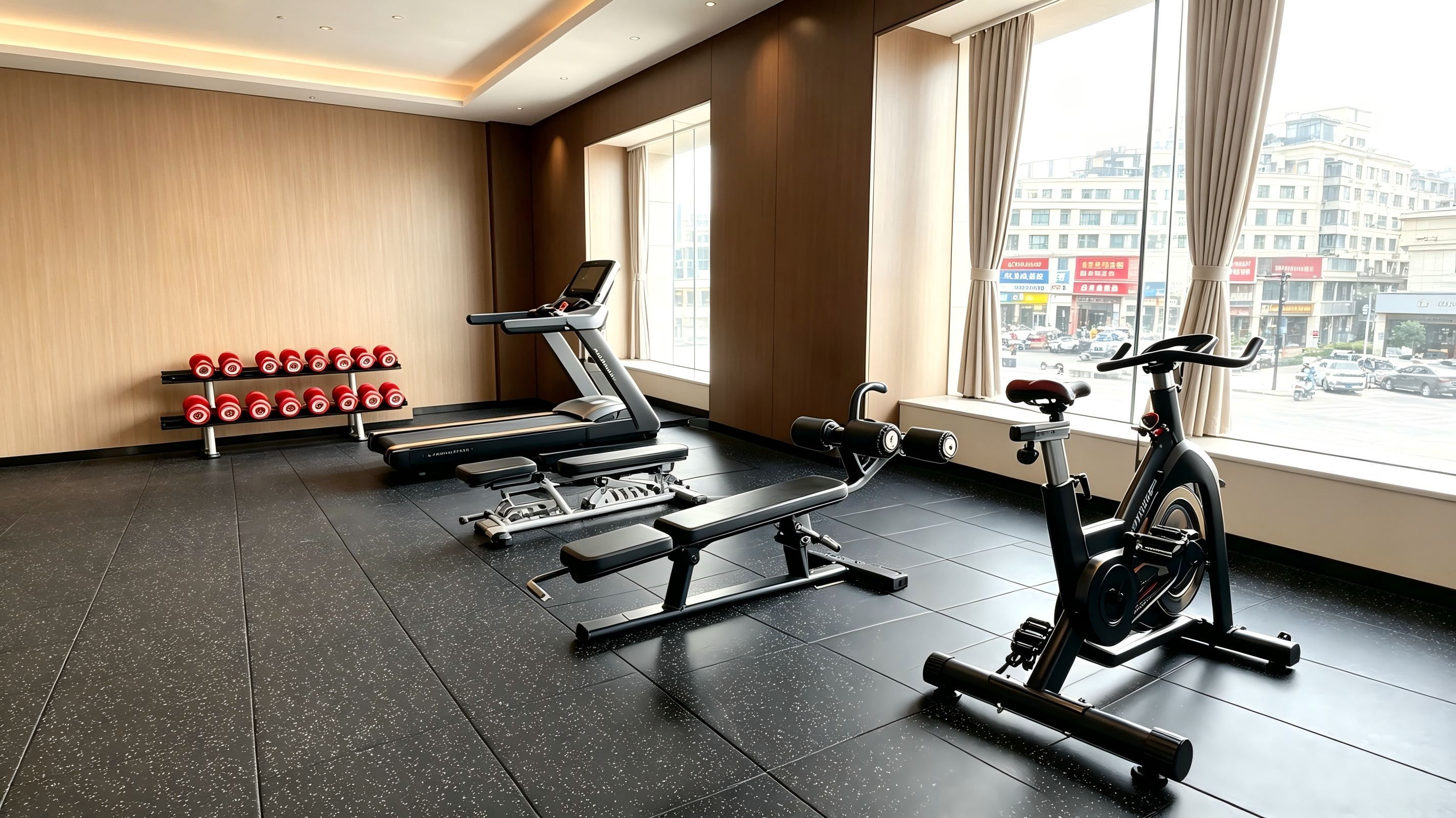 Un gimnasio con equipo de ejercicios, una banca y una ventana con vistas a la ciudad.