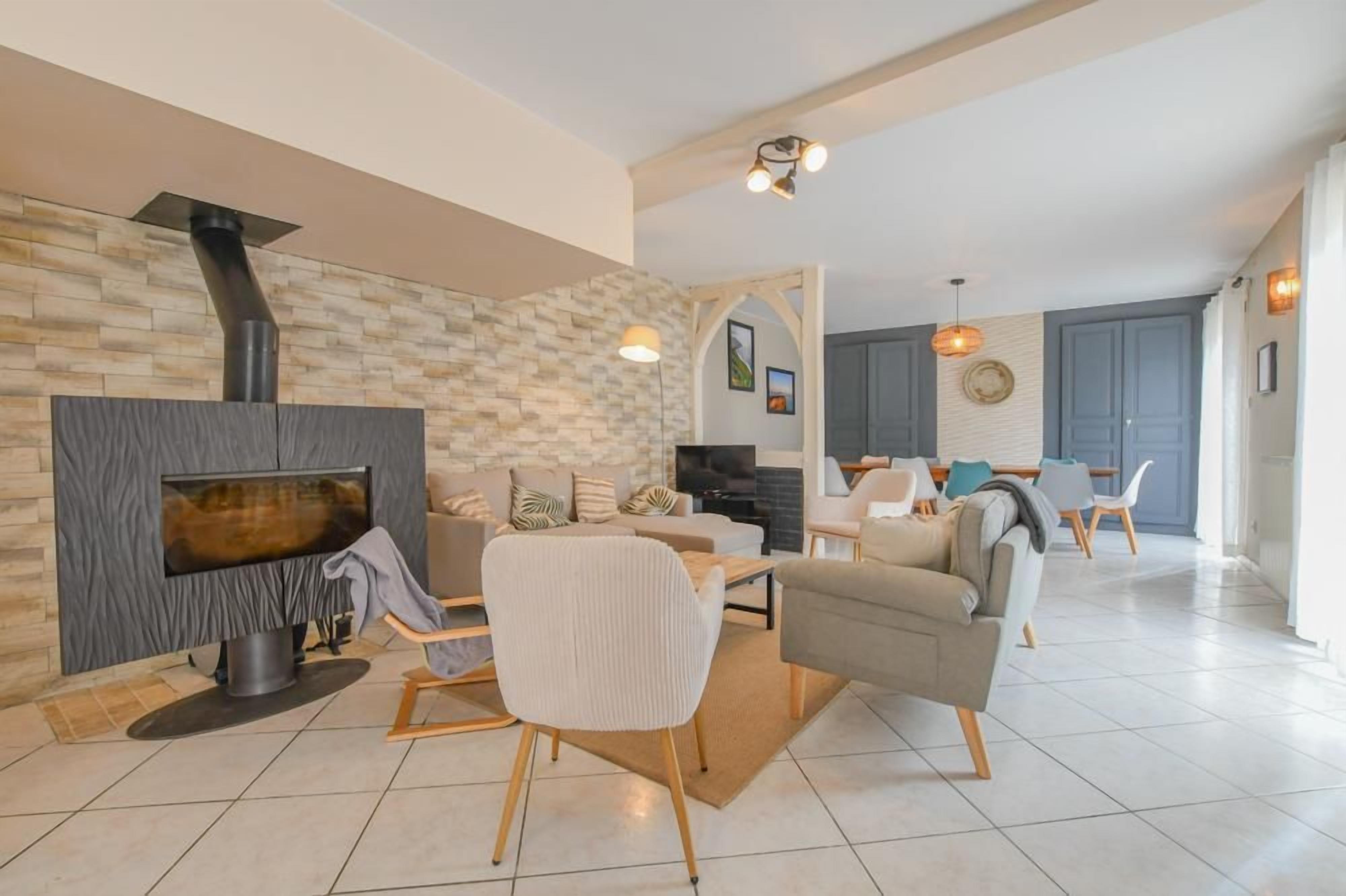 Ein modernes Wohnzimmer mit Kamin, Fernseher und einem Essbereich mit Stühlen und Tisch.