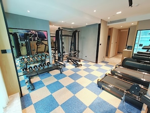 A gym with weightlifting equipment, treadmills, and a checkered floor. - ROSEDALE HOTEL SHENZHEN (Shenzhen)