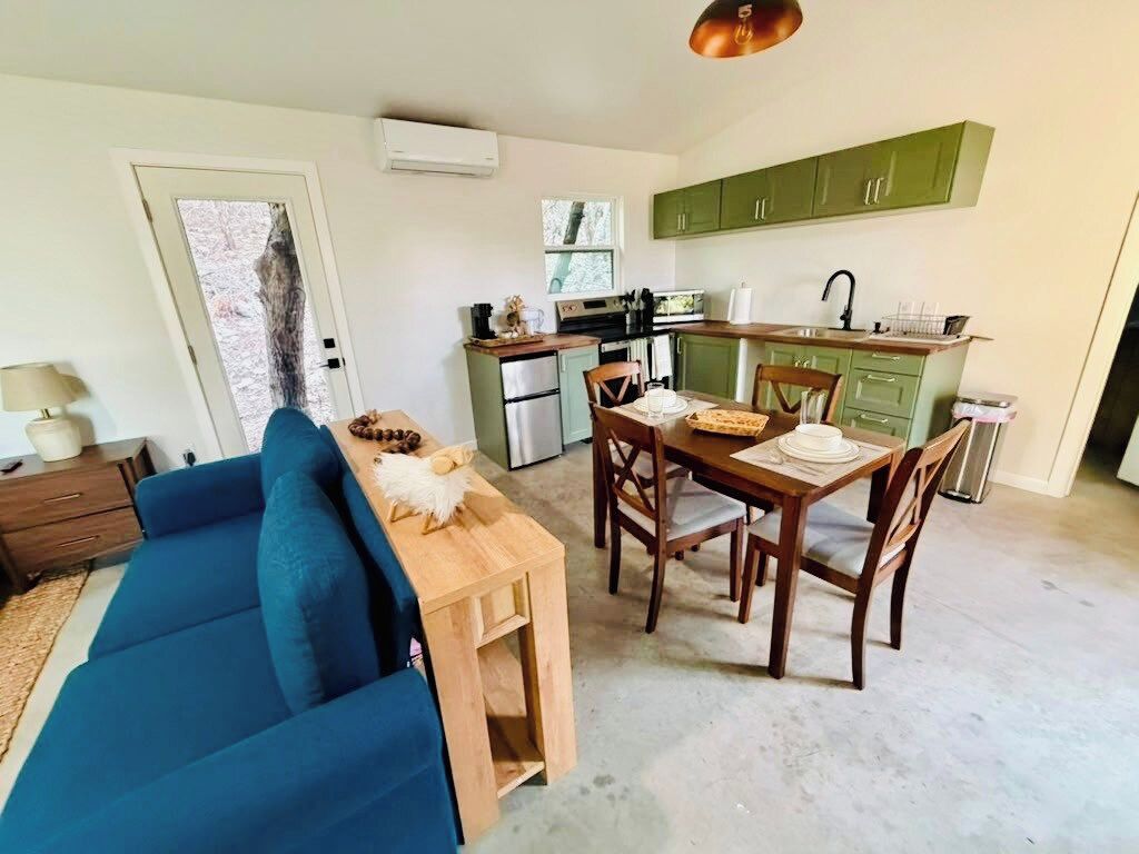 Un espace de vie compact comprenant un coin repas, une kitchenette et un canapé.