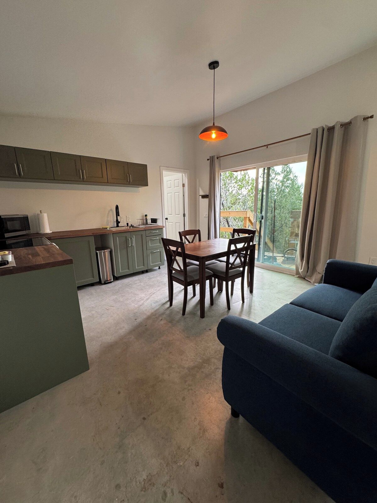 Una cocina moderna con comedor, sofá y un amplio ventanal.