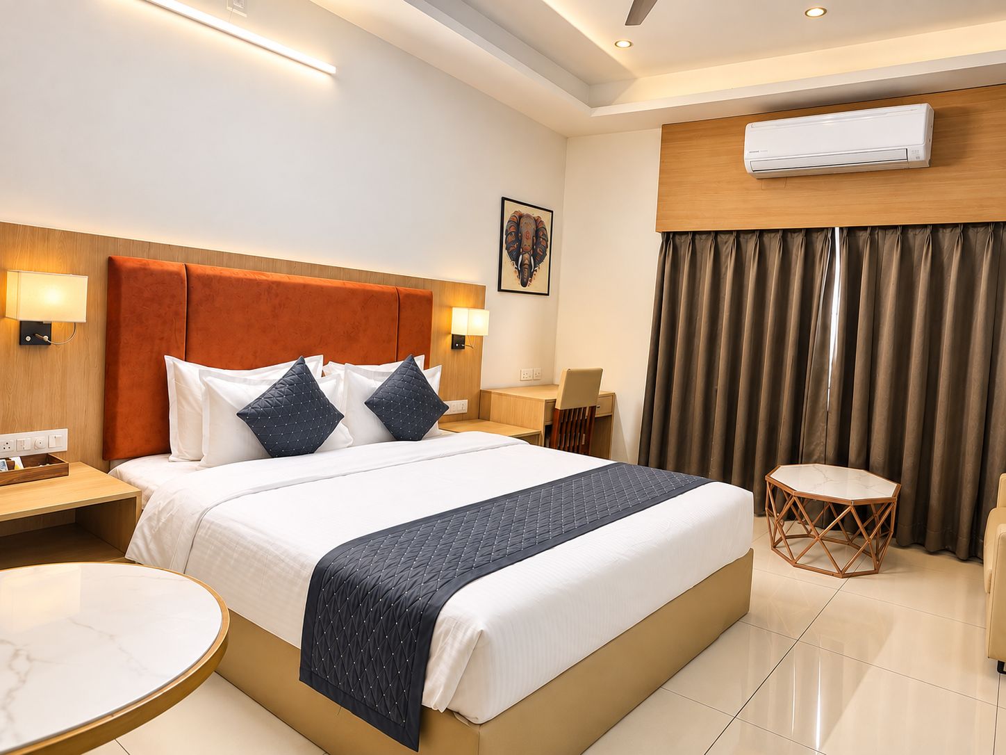 Une chambre d’hôtel comprenant un lit, des tables de chevet, un bureau, une chaise, une table ronde et un appareil de climatisation.