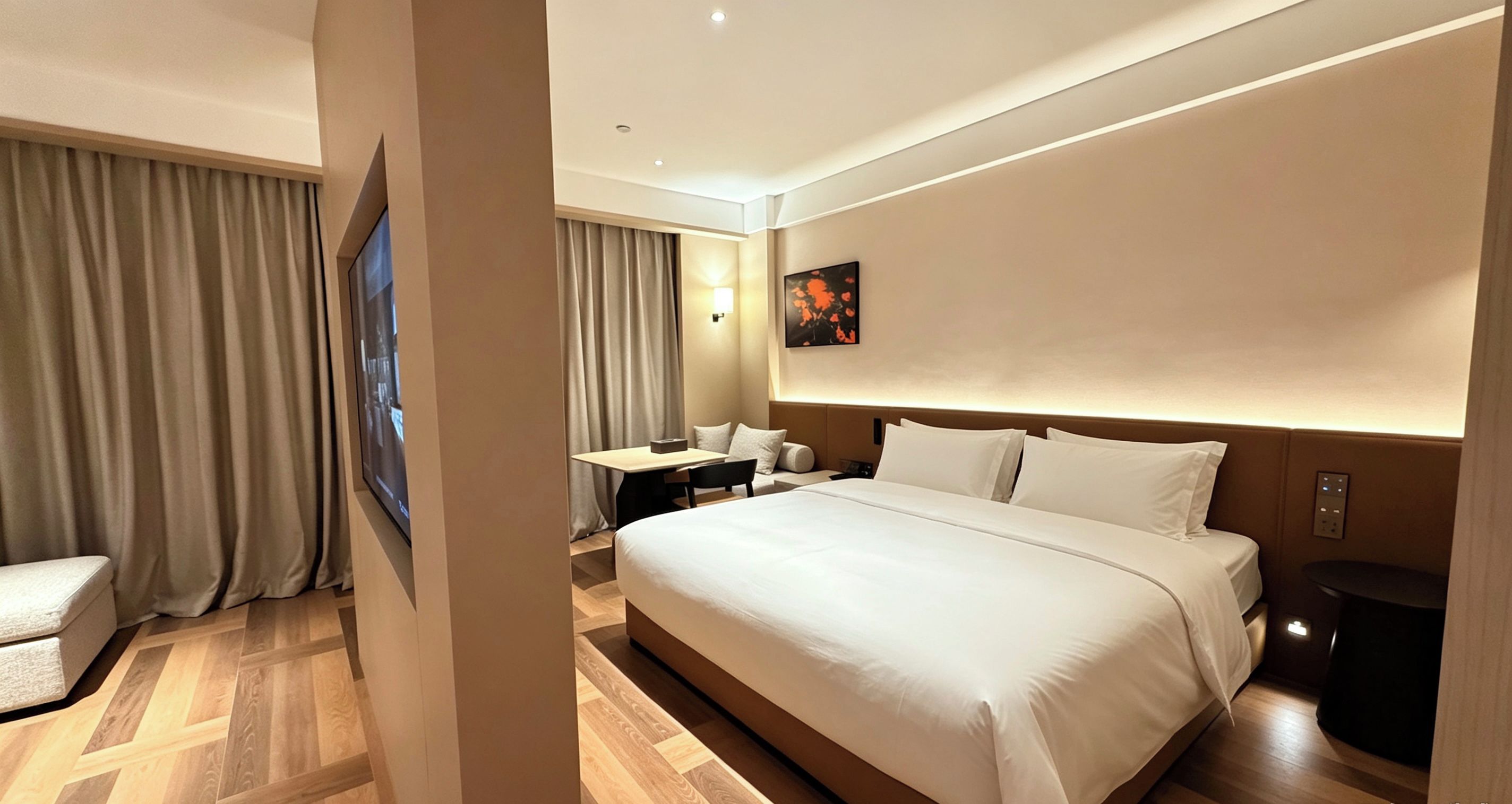 A hotel room with a large bed, a desk, and a chair.