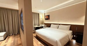 Una habitación de hotel con una cama grande, un escritorio y una silla.