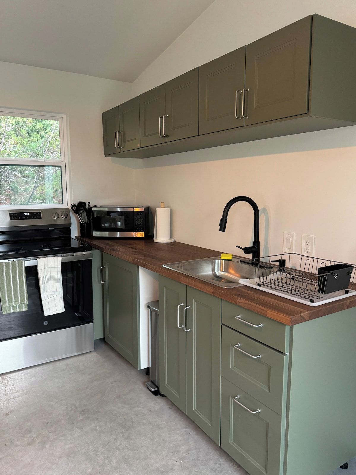 A modern kitchen with a built-in oven, microwave, and stainless steel sink.