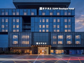 A modern hotel with a prominent entrance and illuminated signage. - SSAW Boutique Hotel Shenzhen Exhibition (Shenzhen)