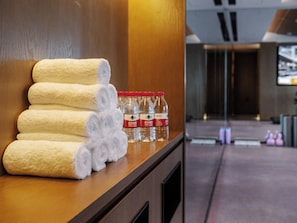 A hotel reception area with a wooden counter displaying neatly rolled towels and water bottles. - SSAW Boutique Hotel Shenzhen Exhibition (Shenzhen)