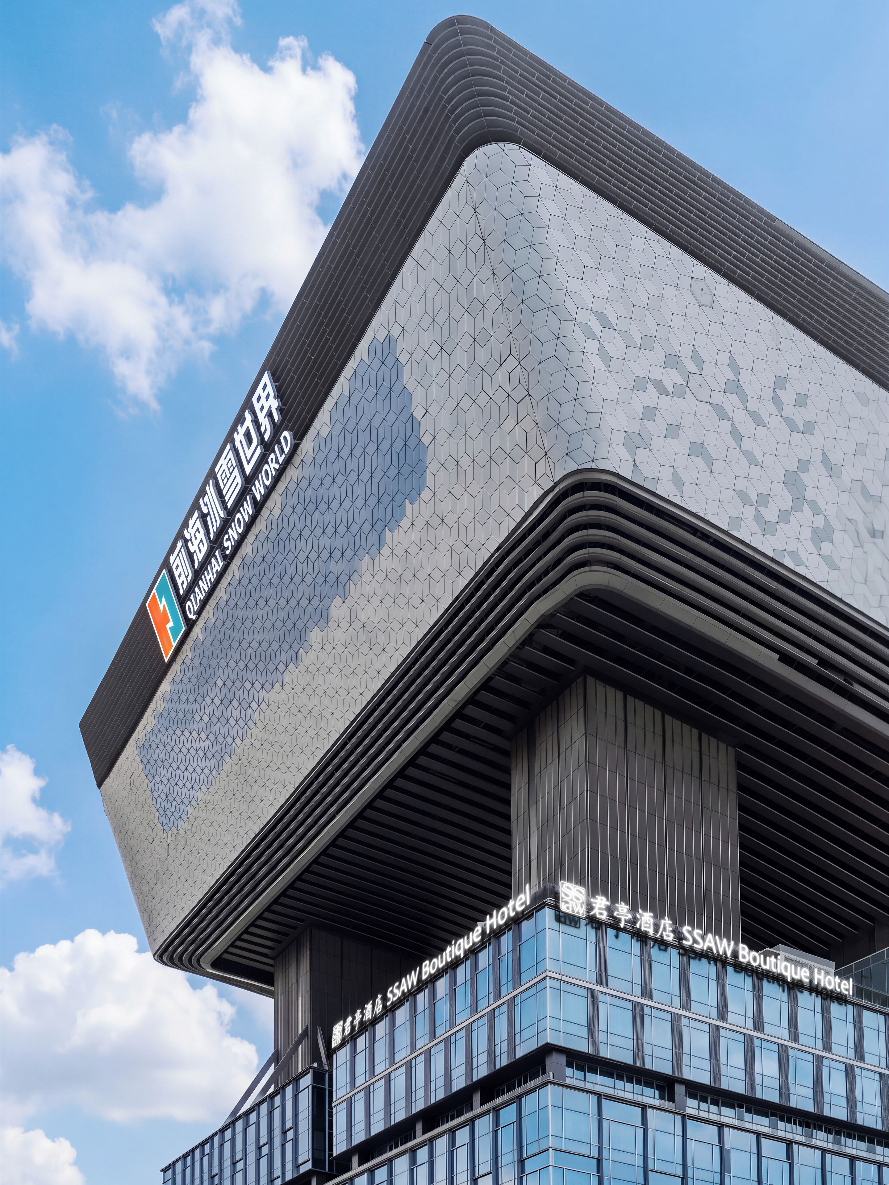 A modern building with a distinctive geometric facade and a sign for the SSAW Boutique Hotel.