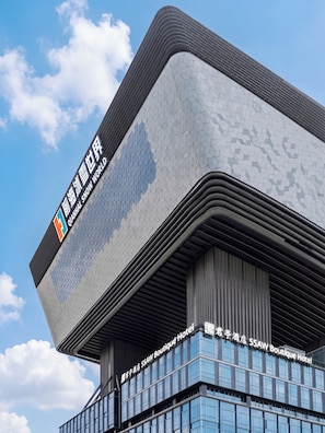A modern building with a distinctive geometric facade and a sign for the SSAW Boutique Hotel. - SSAW Boutique Hotel Shenzhen Exhibition (Shenzhen)