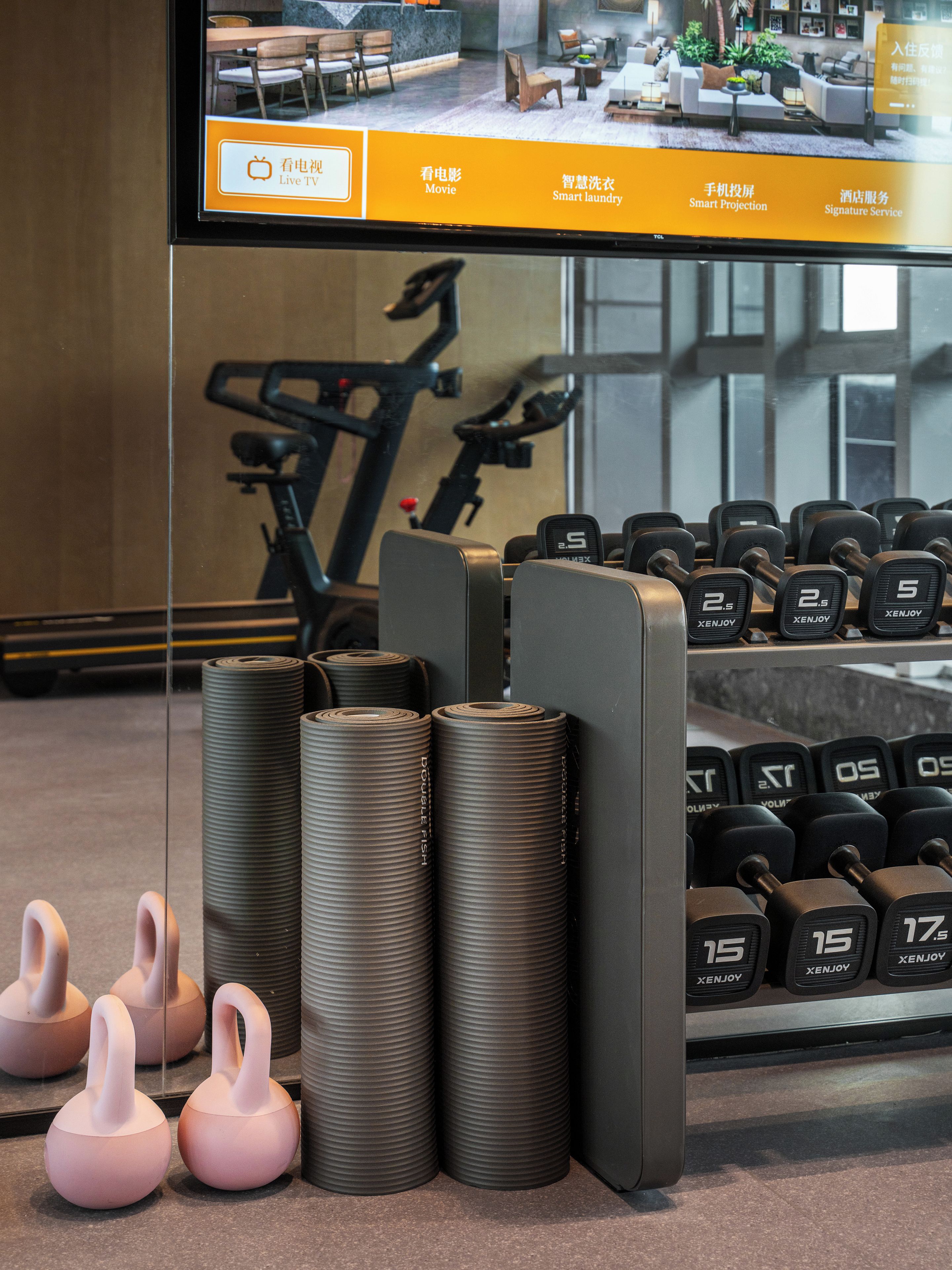 A gym with exercise equipment, including dumbbells and kettlebells.