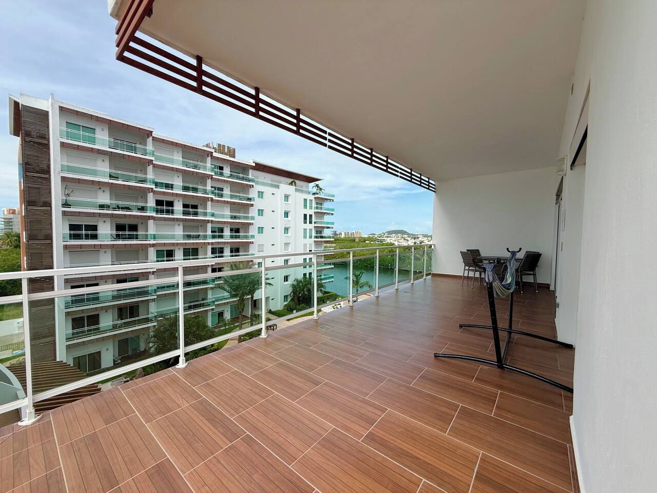 Un balcon donnant sur un immeuble à plusieurs étages et une piscine.