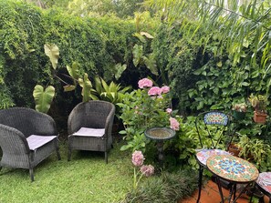 A garden with wicker furniture, a mosaic table, and potted plants. - Family Townhouse Randwick (Randwick)