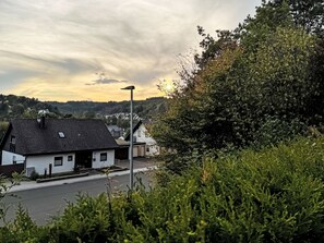 Ein Wohngebiet mit Häusern, einer Straße und einer Hügelkette im Hintergrund.