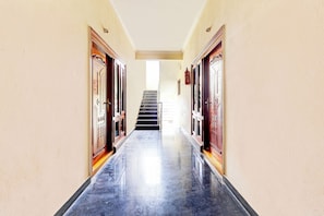 Un pasillo con puertas a ambos lados que conduce a una escalera.