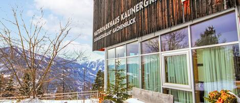 Un edificio con fachada de madera y un letrero que dice 'NATURPARKHAUS KAUNERGRAT'.