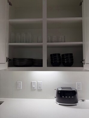 A kitchen with white cabinets, a toaster on the counter, and a wall-mounted electrical outlet. - Spacious 4BR Retreat on 2 Acres •Sleeps 9 (San Benito)