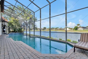 Una piscina interior con vista a un cuerpo de agua y un cielo despejado.