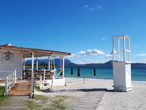 A beachside structure with a covered seating area and a lifeguard tower. - Holiday Home in Olbia With Swimming Pool (Olbia)