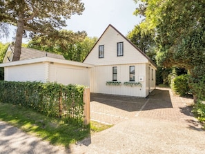 A two-story house with a sloped roof, a front porch, and a number '66' sign. - Holiday Home in Renesse With Swimming Pool (Renesse)