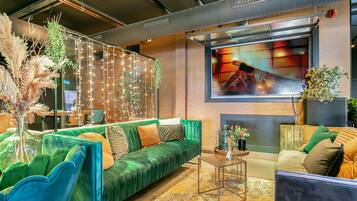 Ein modernes Wohnzimmer mit einem grünen Sofa, einem Couchtisch und einem Kamin.