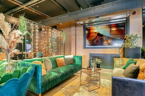 A modern living room with a green sofa, a coffee table, and a fireplace.