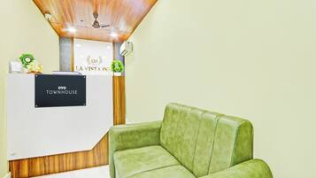 A reception desk with a sign reading 'LVI LA VISTA INN TOWNHOUSE' and a green upholstered chair in front.