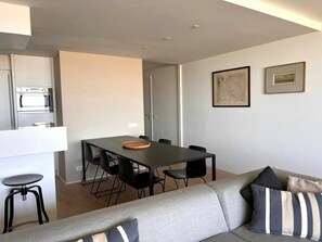 A modern living room with a grey sofa, black chairs, and a dining table. - Residence Cadzand 88-8 (Cadzand-Bad)