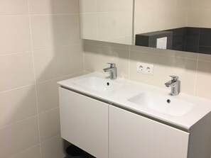 A bathroom with two sinks, a mirror, and a cabinet. - Residence Cadzand 88-8 (Cadzand-Bad)