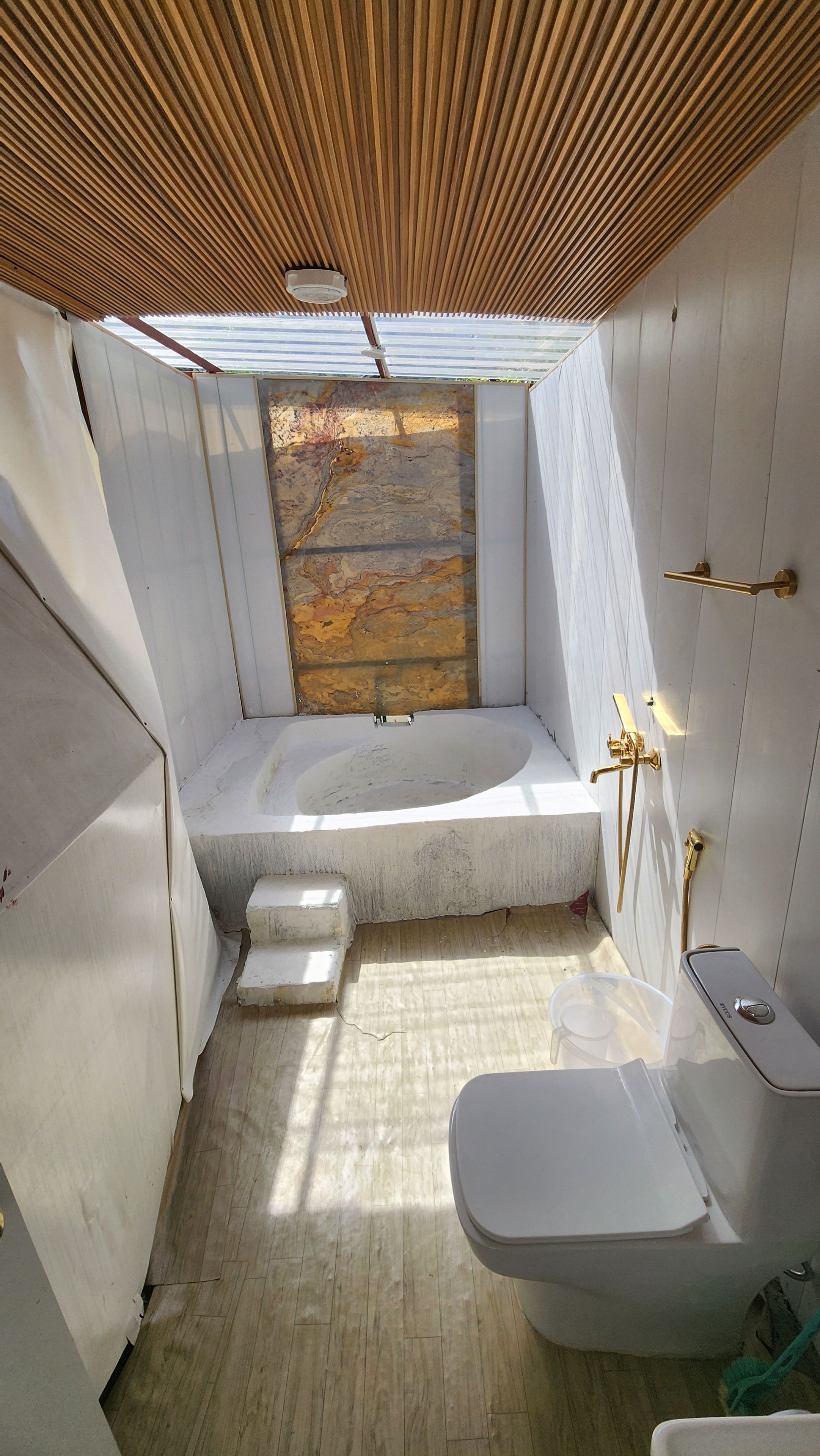 A compact bathroom with a bathtub, a toilet, and a shower area.